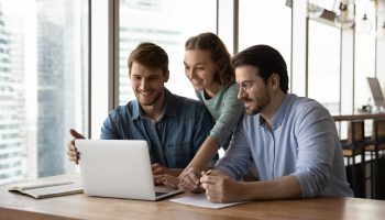 Happy,Three,Teammates,Working,Together,On,Online,Project,,Sitting,At