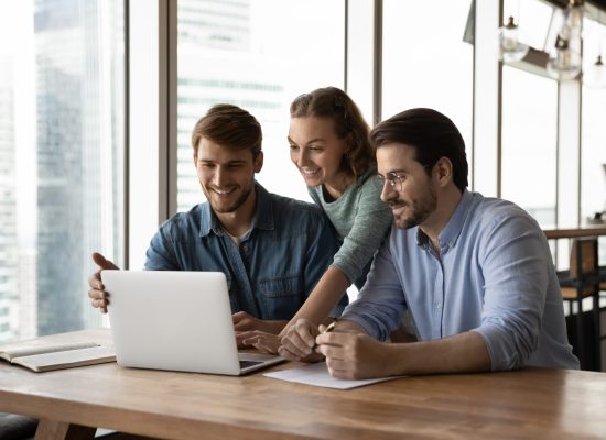 Happy,Three,Teammates,Working,Together,On,Online,Project,,Sitting,At